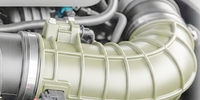 The image shows a close-up of a part of an automotive engine, specifically an air intake component.